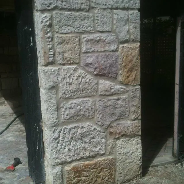 Worker installing steel lintel on brick facade