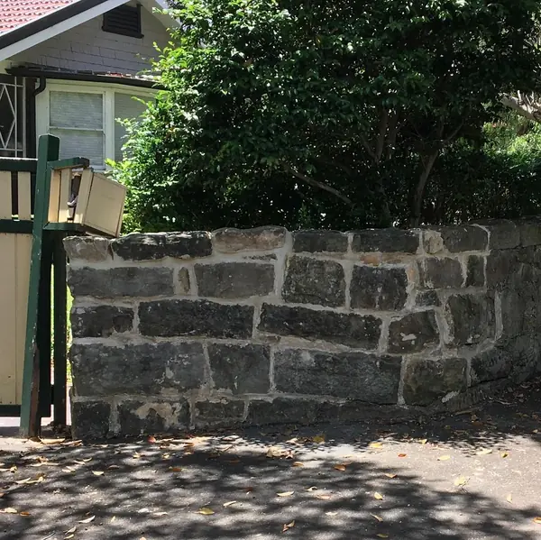 New sandstone retaining wall with garden landscaping