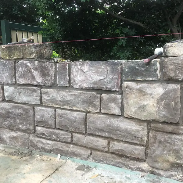 Sandstone block retaining wall in garden setting