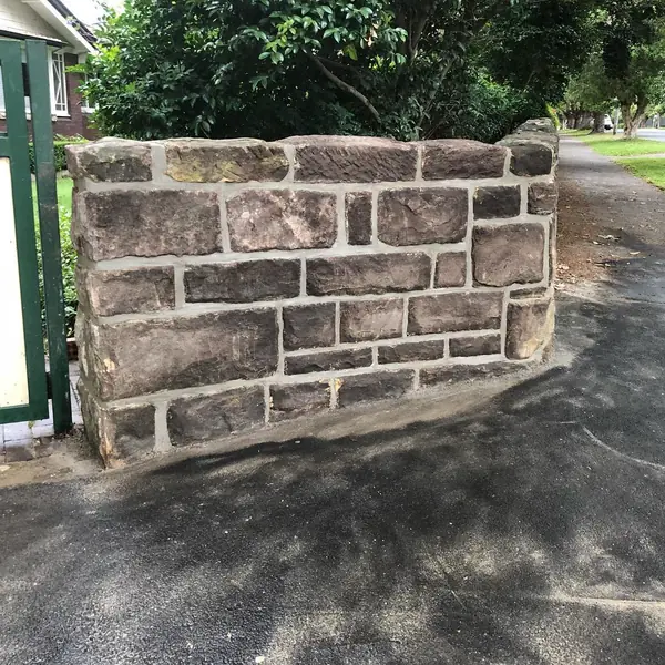 Completed sandstone retaining wall along garden bed