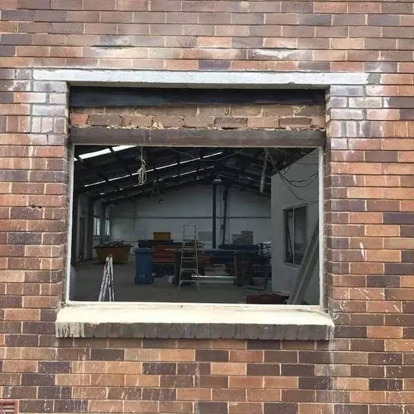 Bricklayer working on structural opening in brick facade
