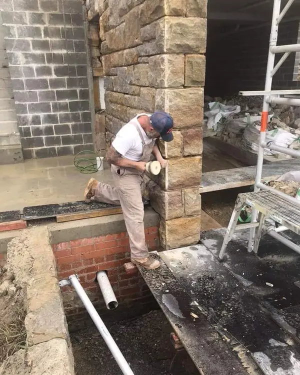 Stonemason working on heritage sandstone building facade