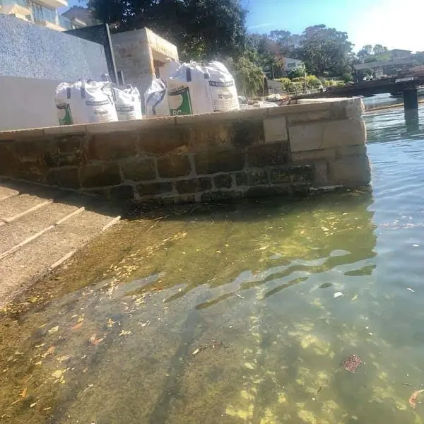 Waterfront sandstone wall restoration near wharf
