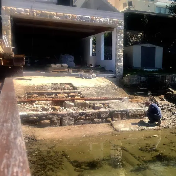 Harbour sandstone seawall with jetty in background