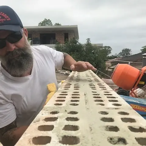 Minas laying bricks with spirit level on residential project