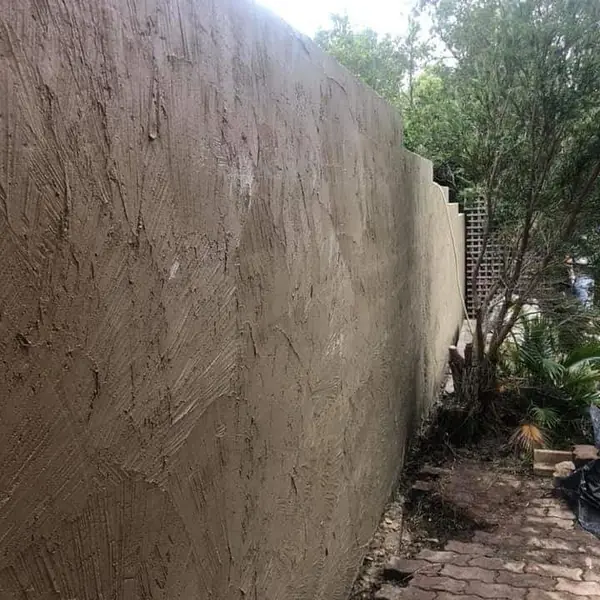 Freshly rendered retaining wall along garden pathway
