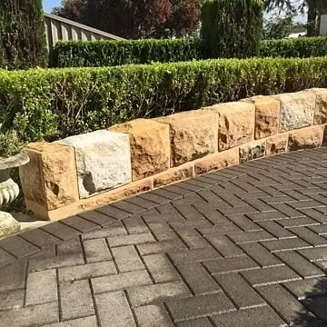 Excavator assisting with harbour sandstone wall rebuild