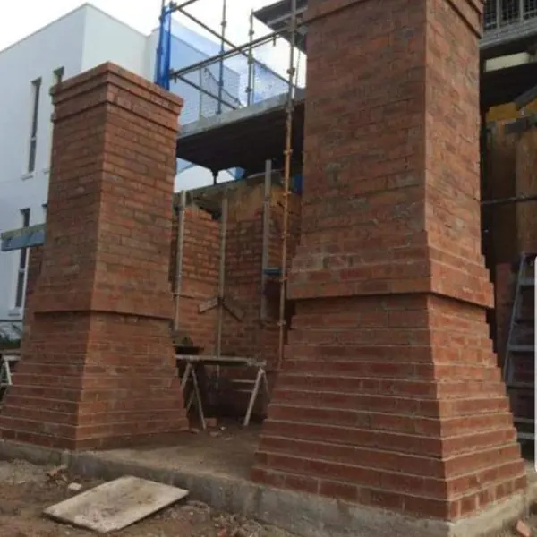 New brick entrance pillars with scaffolding on-site