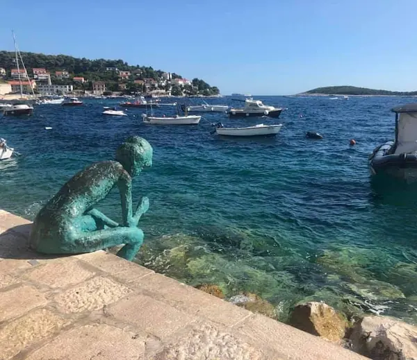 Bronze sculpture on heritage stone harbour wall
