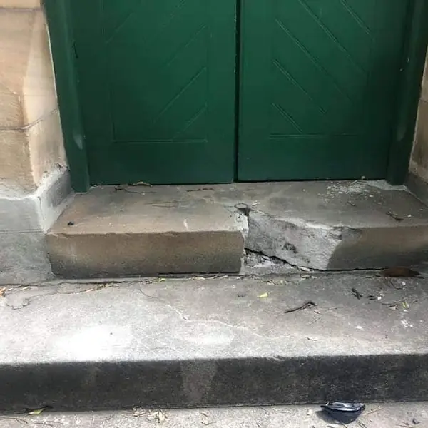 Cracked sandstone doorstep requiring heritage repair
