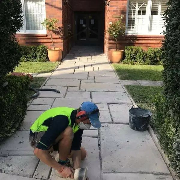 Natural sandstone flag paving being laid on pathway
