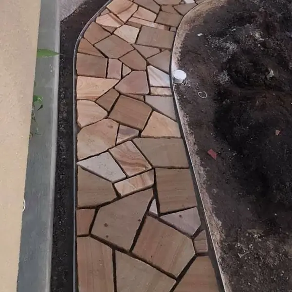 Natural stone pathway installation at residential property