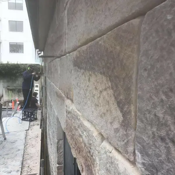Sandstone block feature wall under construction indoors