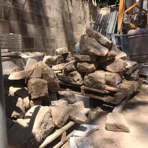 Stone veneer cladding installation on retaining wall
