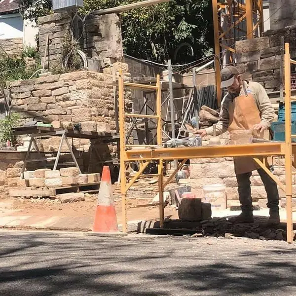 Natural stone cladding on block wall in progress