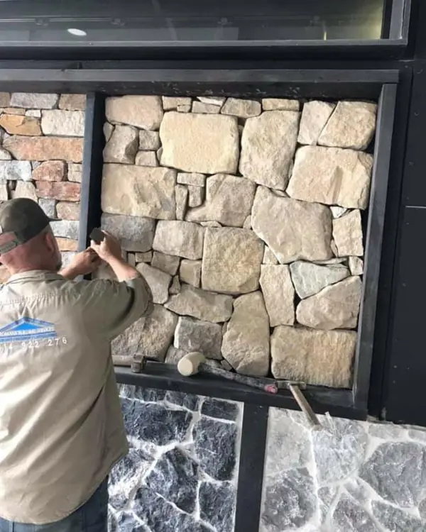 Worker installing natural stone feature wall panel