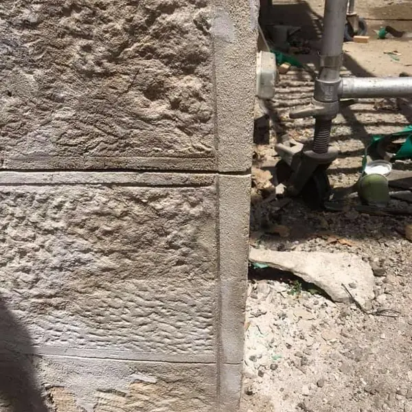 Split-face sandstone block wall rising on building site