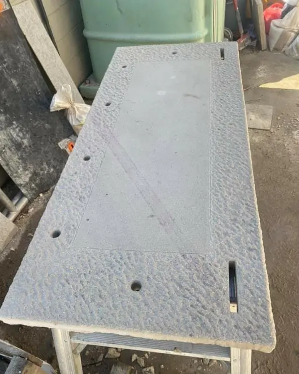 Textured sandstone slab being shaped with rotary tool