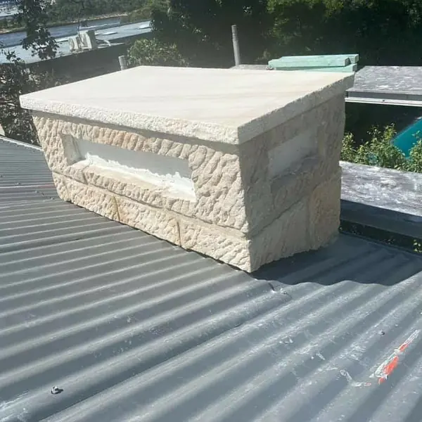 Hand-dressed sandstone blocks being laid for chimney