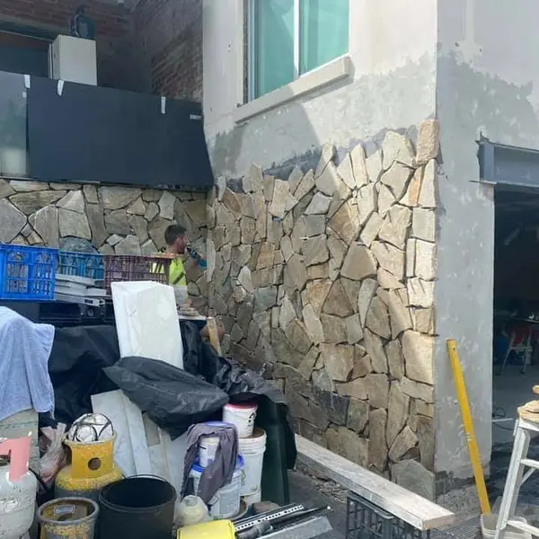 Natural stone cladding on residential exterior in progress