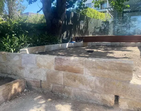 New sandstone block retaining wall with timber deck beyond