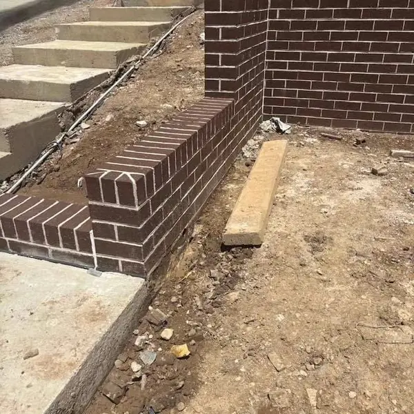 Block retaining wall with stepped foundation design